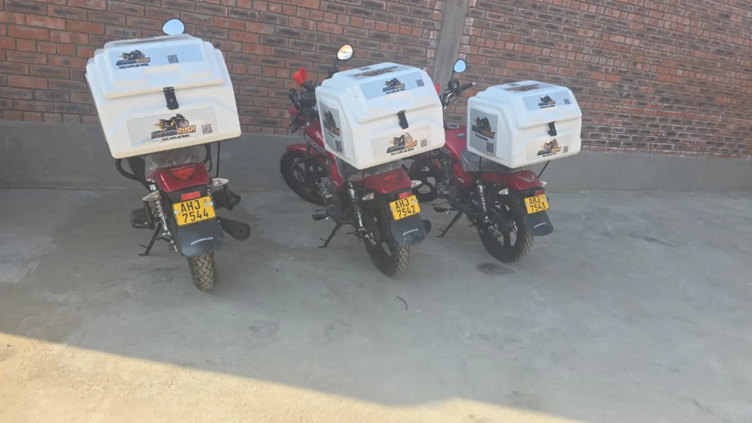 Three SmoothRush motorcycles equipped with delivery boxes